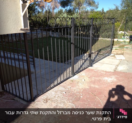 גדר מתכת שחורה עם שערים פתוחים
